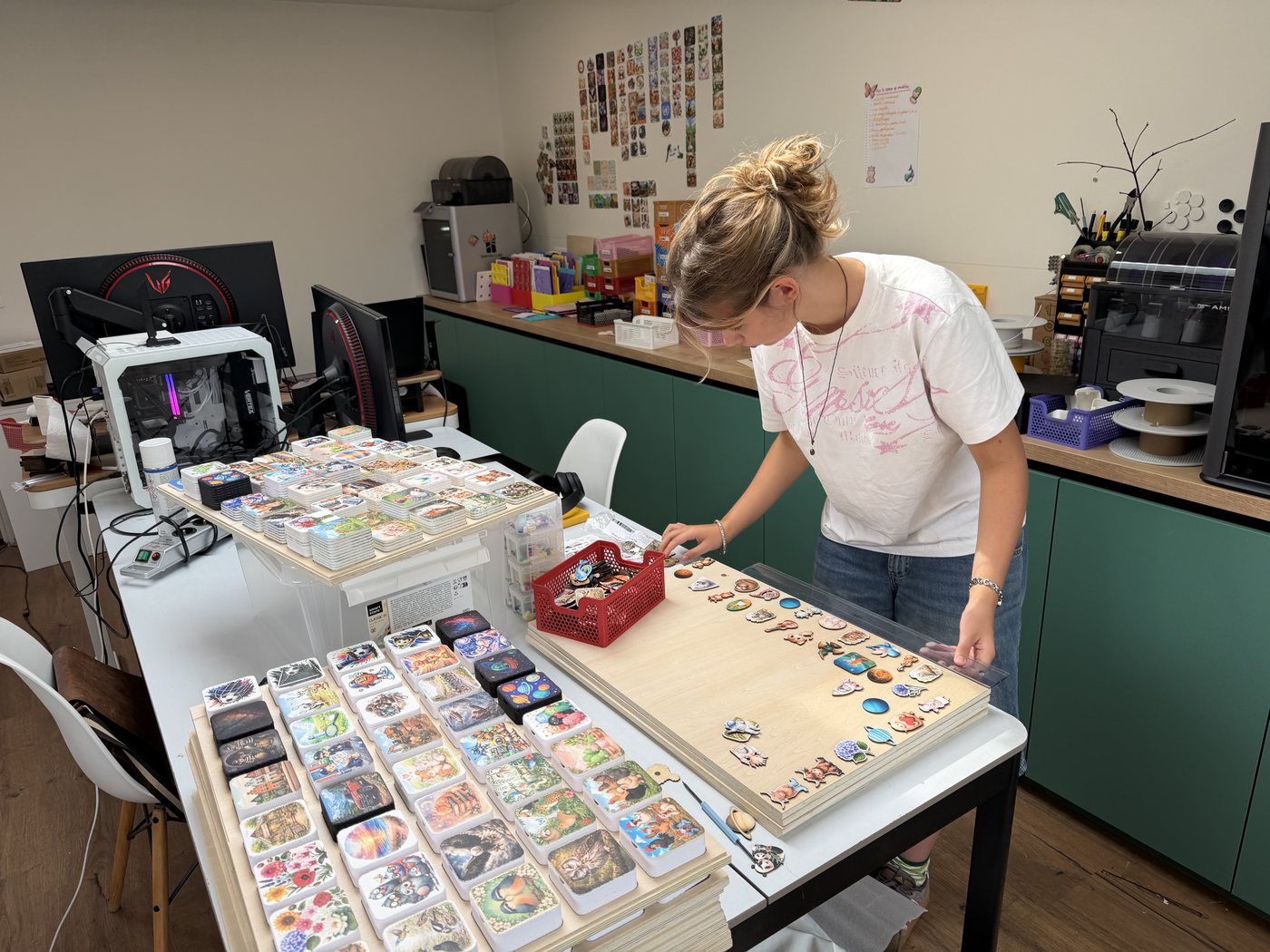 The workshop: display boards being restocked by hand, printers and filament stations along the wall